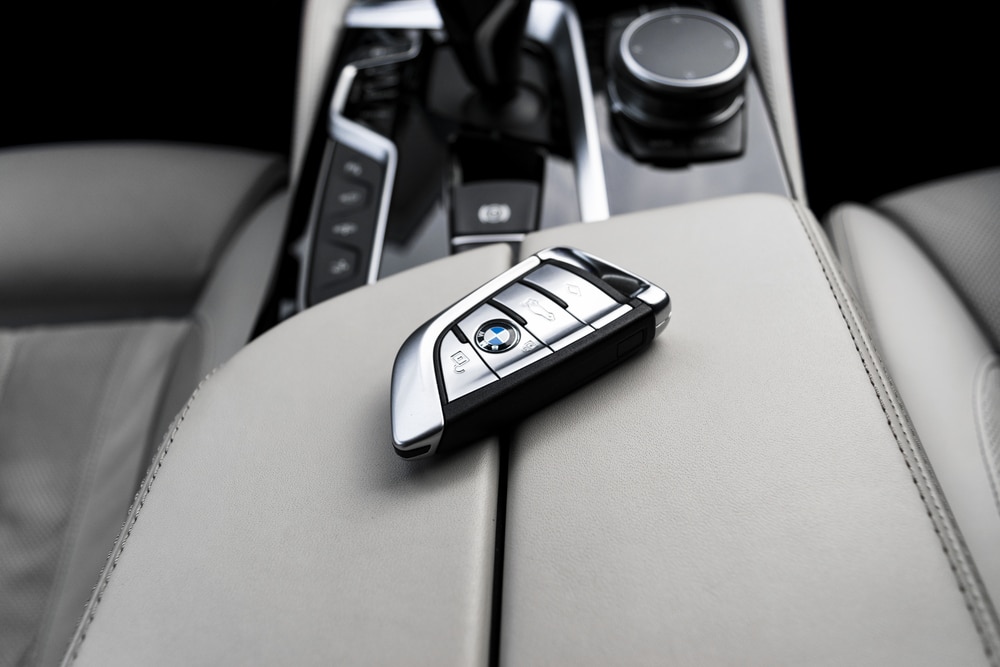 Close up of modern wireless keys of BMW 650i 2019 in white leather car interior. Modern Car interior details. Car inside