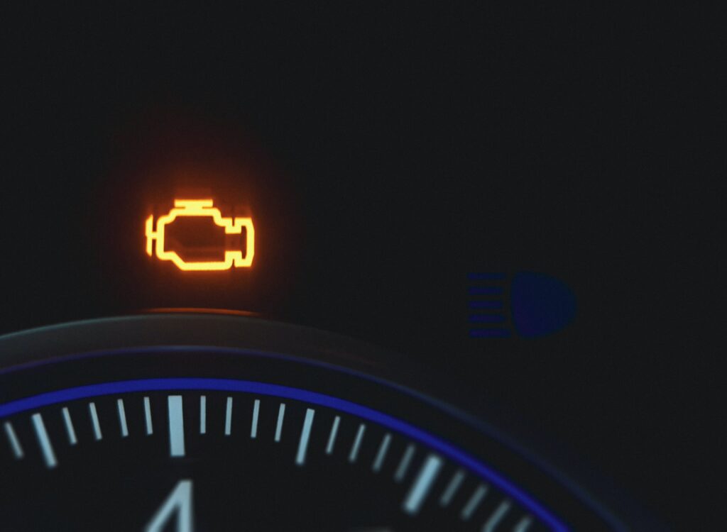 A car dashboard with a check engine light illuminated