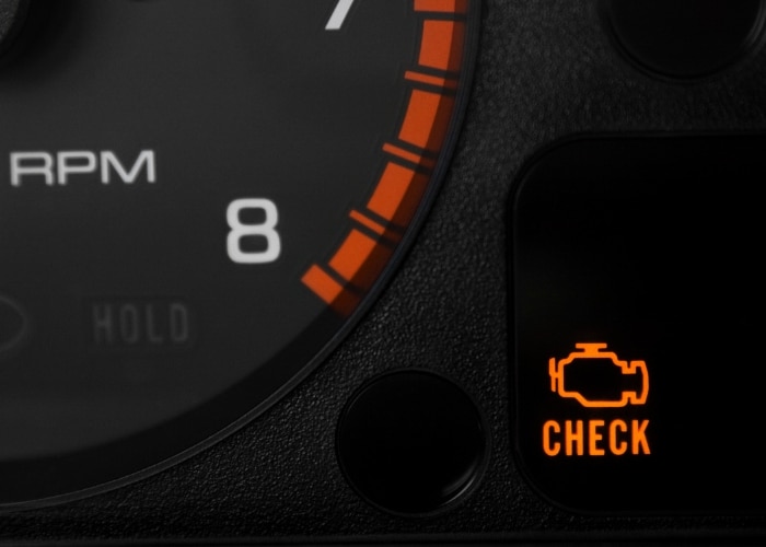 The check engine light illuminated on a BMW dashboard, indicating a potential issue.